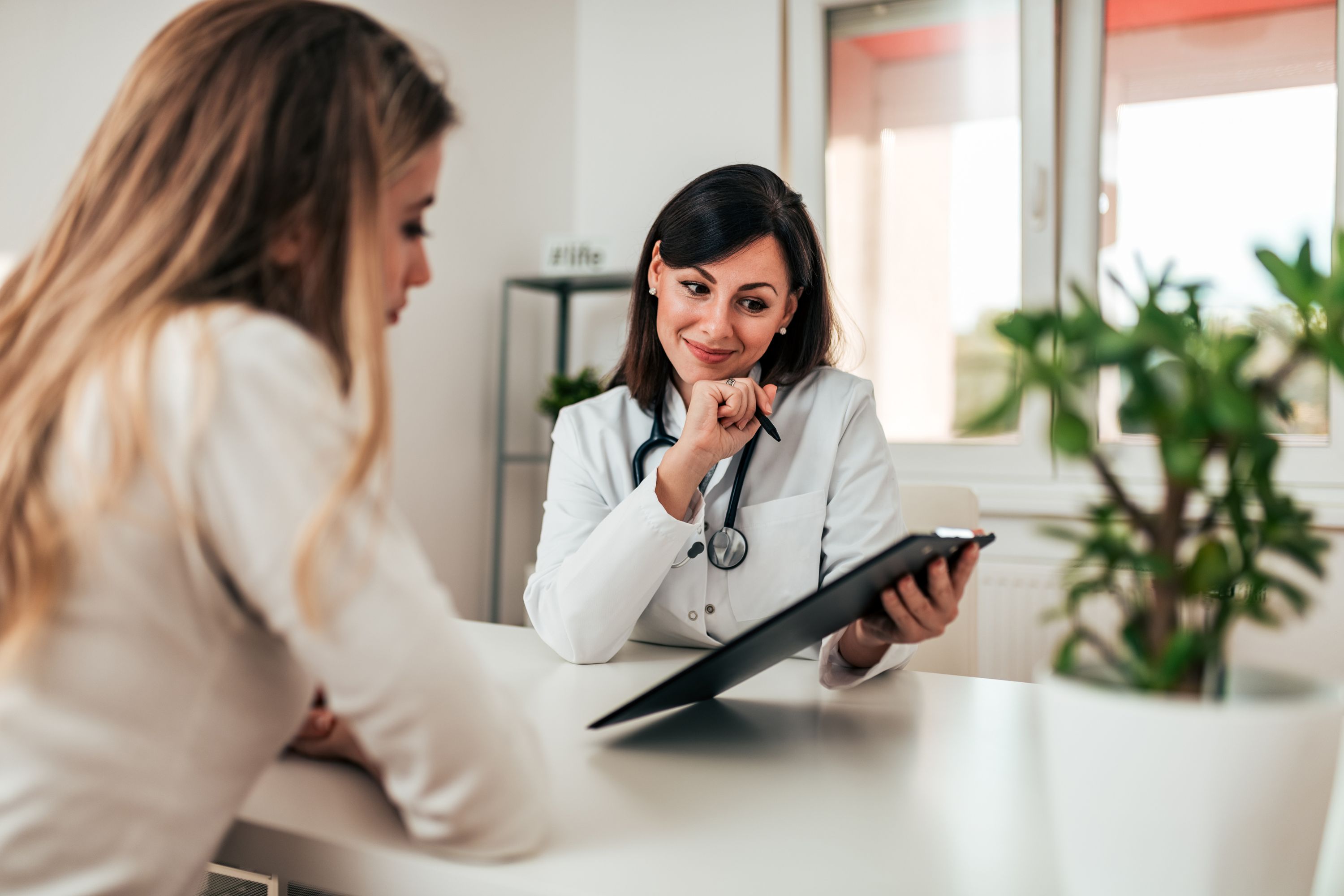 Doctor reviewing women's health and fertility optimization programs with patient, offering personalized guidance