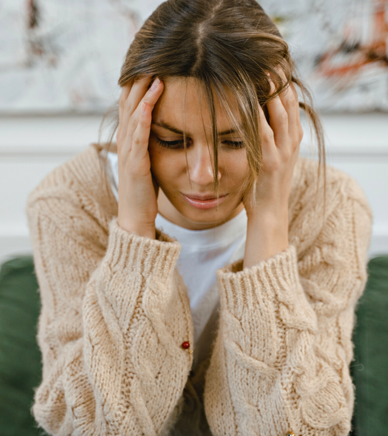 Frustrated woman holding her head, facing ongoing health challenges and looking for personalized women's health solutions