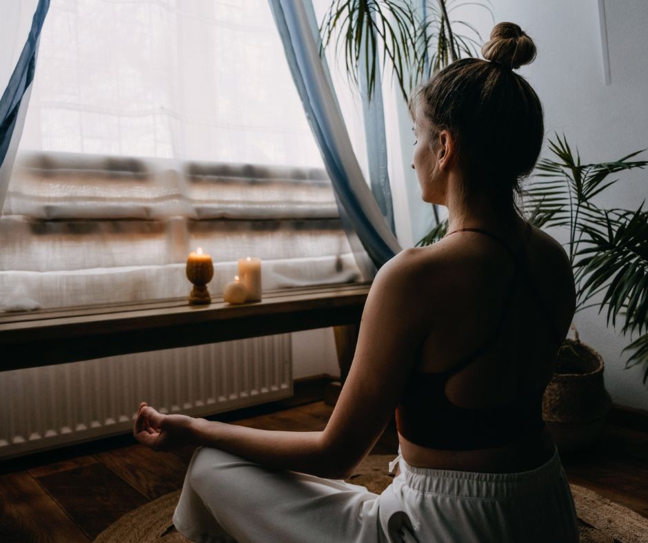 woman meditating in front of window